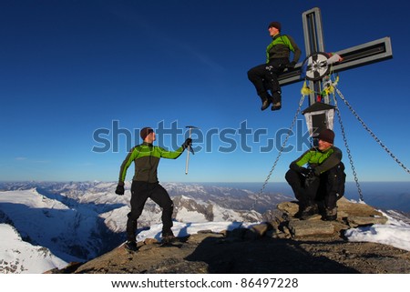 Three identical man on a mountain summit