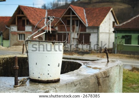 bucket on the side of a well in a village