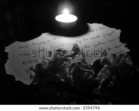Poem on burnt paper and flower in candle light