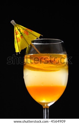 Triple layered drink with spiral lemon slice in studio light