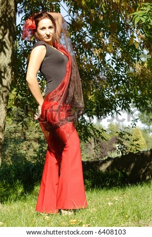 Model with red pants and red scarf in the park