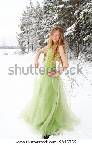 Beautiful young woman wearing prom dress in snowy setting