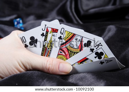Revealing Royal Flush of clubs on black background