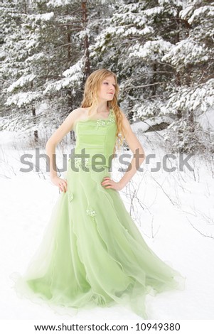 Beautiful young woman wearing prom dress in snowy setting