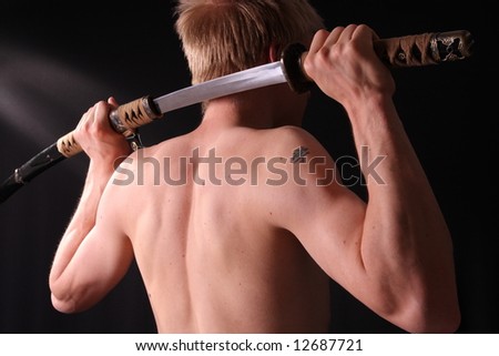 Closeup of man holding samurai sword in dramatic studio light