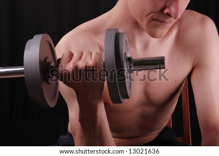 Man training with weight in dramatic studio light