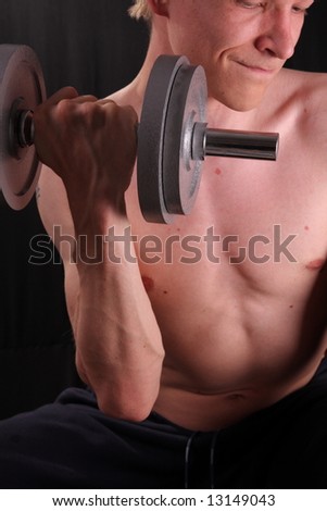 Man training with weight in dramatic studio light
