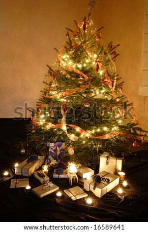 Christmas presents and candles under the tree