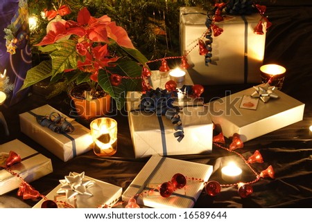 Christmas presents and candles under the tree