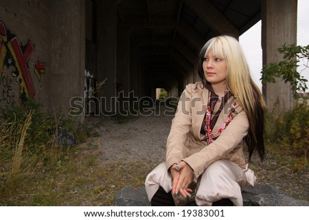 Beautiful young woman, fashion model, black and blond hair in industrial location