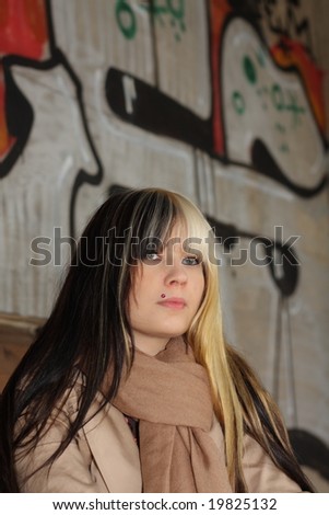 Beautiful young woman, fashion model, black and blond hair in industrial location