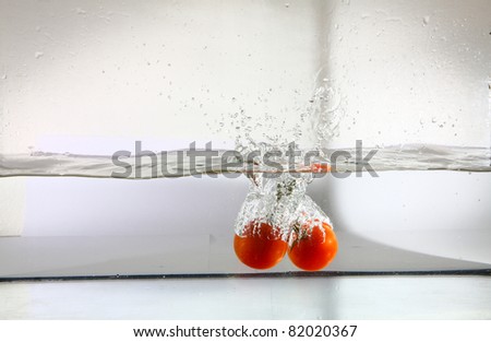 Bunch of tomatoes falling in water