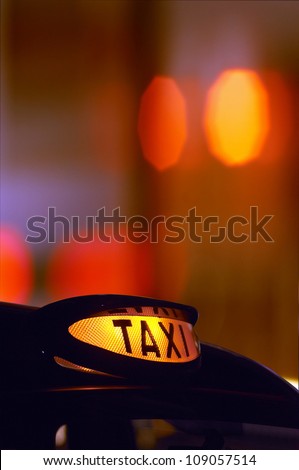 a british london black taxi cab sign at night with colorful background