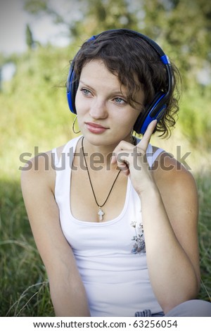A young girl listens to music on the nature