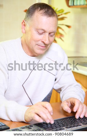 Senior man using computer, researching online at home