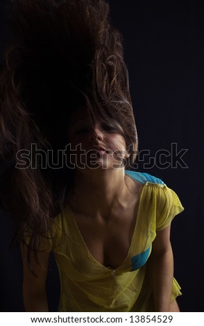 woman with fly-away hairs on black background, low-key