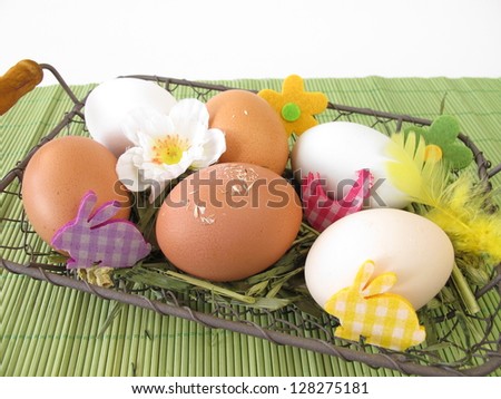 Eggs in natural white, brown and green colors in easter basket