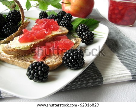 Breakfast with sliced bread and jam consist of apples and blackberries