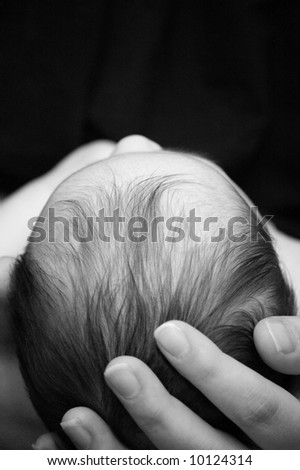 Woman holding infants head in hands