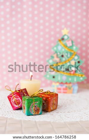 Christmas concept. Gift box, candle and tree with pink background