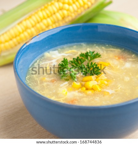 Chinese chicken and corn soup with fresh corn cob on the side.