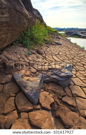 Rock and ground cracks on dry surface of the ground