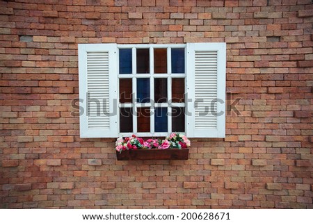 Square window on the brick wall and flower