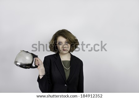 Unhappy young woman in business attire holding coffee pot
