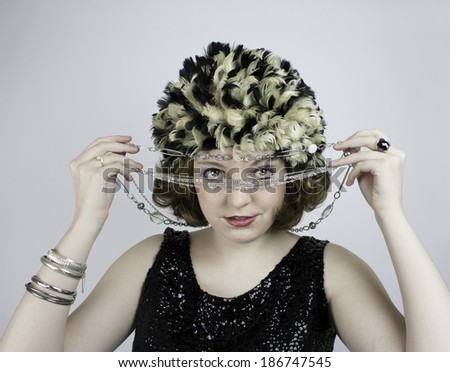 Beautiful young woman wearing vintage feather hat and vintage black sequin tank top