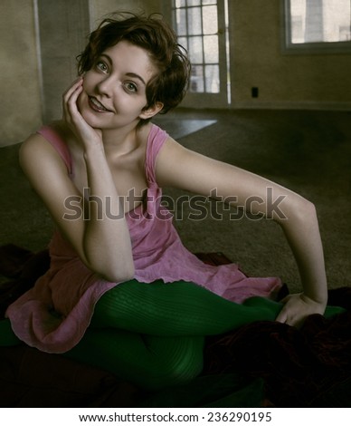 Beautiful young woman sitting cross-legged on the floor