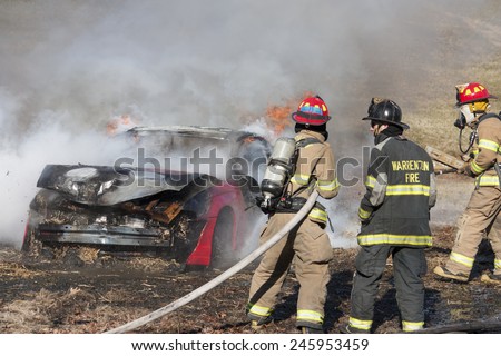 New Baltimore, Virginia, USA-January 17, 2015: Firemen training on a burning car at the New Baltimore Fire Station in New Baltimore, Virginia.