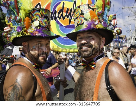 Provincetown, Massachusetts, USA-August 20, 2015: Two men wearing hats walking in the 37th Annual Provincetown Carnival Parade in Provincetown, Massachusetts.