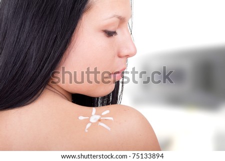 Sunscreen lotion over tan woman skin made as sun shape