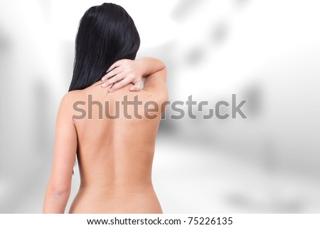 Woman from behind, naked body, holding her neck .