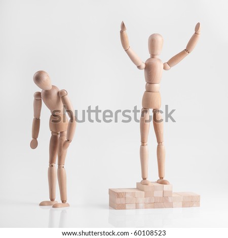 One of wooden figures men standing on the victory podium and celebrates winning. The second man standing next to him frustrated and sad because he lost.