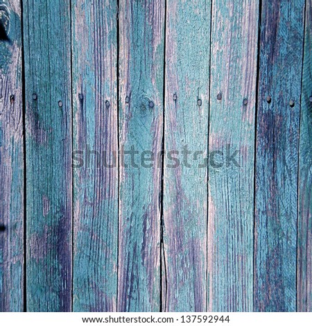 Old  wooden vertical planks background with blue paint cracked