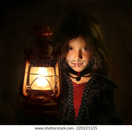 Portrait of Halloween girl with lantern in dark