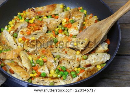 fried chicken breast with vegetables on frying pan
