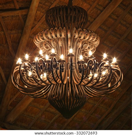 Antique metal ceiling light under straw roof.