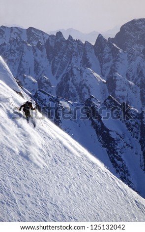 Active man skiing a steep snow slope in Alaska\'s Chugach Mountains in winter