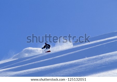 Active man snowboarding in fresh snow in Alaska\'s Chugach Mountains in winter