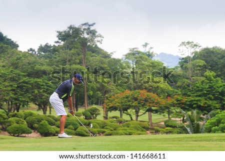 PATTAYA, THAILAND - MAY 29: Unidentified man addressing the the ball on 8th hole at Green Valley St Andrews golf course on May 29, 2013. Pattaya has 25 golf courses close to the city.