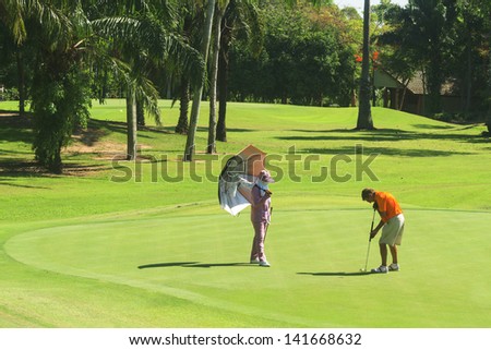 PATTAYA, THAILAND - MAY 29: Unidentified man putting on 8th hole at Green Valley St Andrews golf course on May 29, 2013. Pattaya has 25 golf courses close to the city.