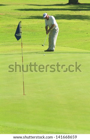PATTAYA, THAILAND - MAY 29: Unidentified man putting on 8th hole at Green Valley St Andrews golf course on May 29, 2013. Pattaya has 25 golf courses close to the city.