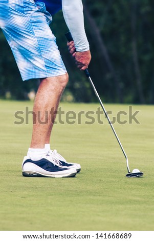 PATTAYA, THAILAND - MAY 29: Unidentified man addressing the ball on green at 4th hole at Green Valley St Andrews golf course on May 29, 2013. Pattaya has 25 golf courses close to the city.
