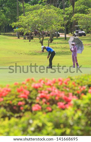 PATTAYA, THAILAND - MAY 29: Unidentified asian man putting on 8th hole on Green Valley St Andrews golf course on May 29, 2013. Pattaya has 25 golf courses close to the city.