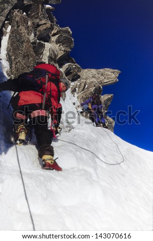 Two men mountain climbing snow and rock on Arete du Cosmique in Chamonix France