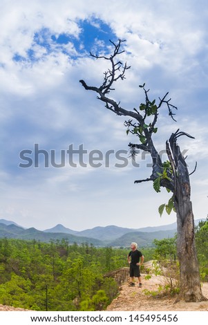 Active man looking at mountain view and lush green trees  in Pai Canyon, thailand