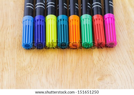 Collection of color pens on a wooden board