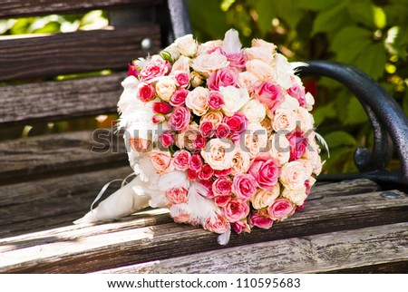 Wedding bouquet with roses on a wooden bench